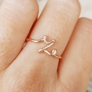 Puede incluir: Una taza de cerámica blanca con un asa negra y el texto "But First, Coffee" en negro, en negrita. La taza está sobre una superficie blanca.