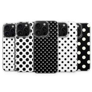 Peut inclure: Cinq coques de téléphone avec un motif à pois noir et blanc. Les coques ont un bord transparent et une découpe pour l'appareil photo. Les pois varient en taille et en densité, créant un design ludique.
