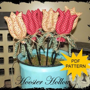 May include: A bouquet of fabric tulips in a light blue metal container. The tulips are red and cream-colored with a floral pattern, tied with twine and green gingham ribbon. The text "PDF PATTERN" is in a yellow starburst.