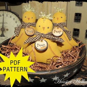 May include: Three yellow fabric chick decorations with brown and white gingham bows and "Peep" tags, nestled in a rustic bowl filled with straw. The bowl is black with white star accents. The image also includes a yellow starburst with the text "PDF PATTERN".