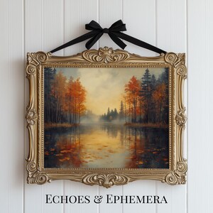 May include: A framed landscape painting with a gold ornate frame and a black ribbon for hanging. The artwork depicts a serene lake scene with autumn trees in shades of orange and red. The text "ECHOES & EPHEMERA" is at the bottom.