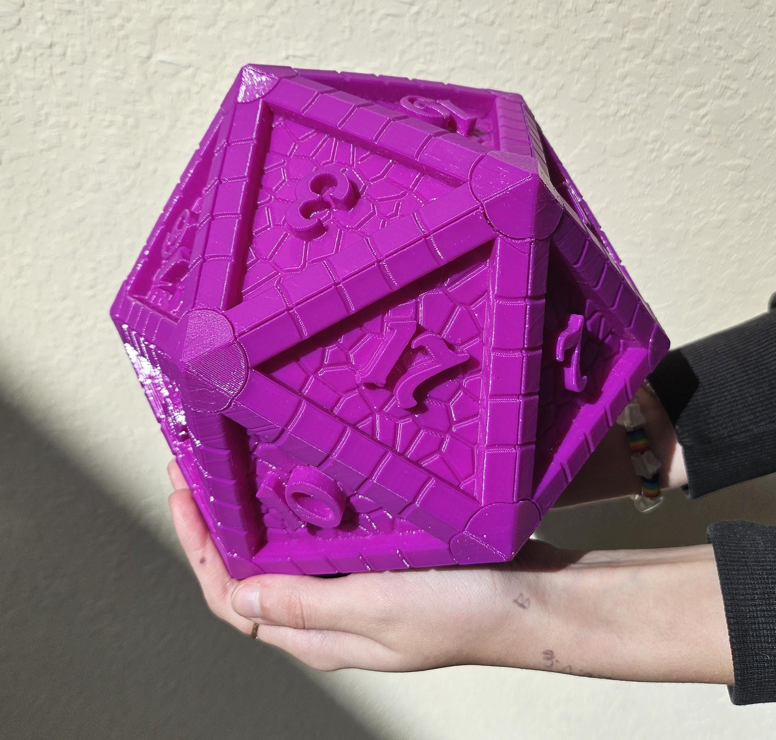A vibrant purple, 3D-printed D20 dice with customizable colors, held in a hand against a plain background.