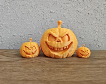 May include: Three orange, carved pumpkin decorations with menacing faces. The pumpkins vary in size, with the largest in the center and two smaller ones on either side. The pumpkins are on a wooden surface.