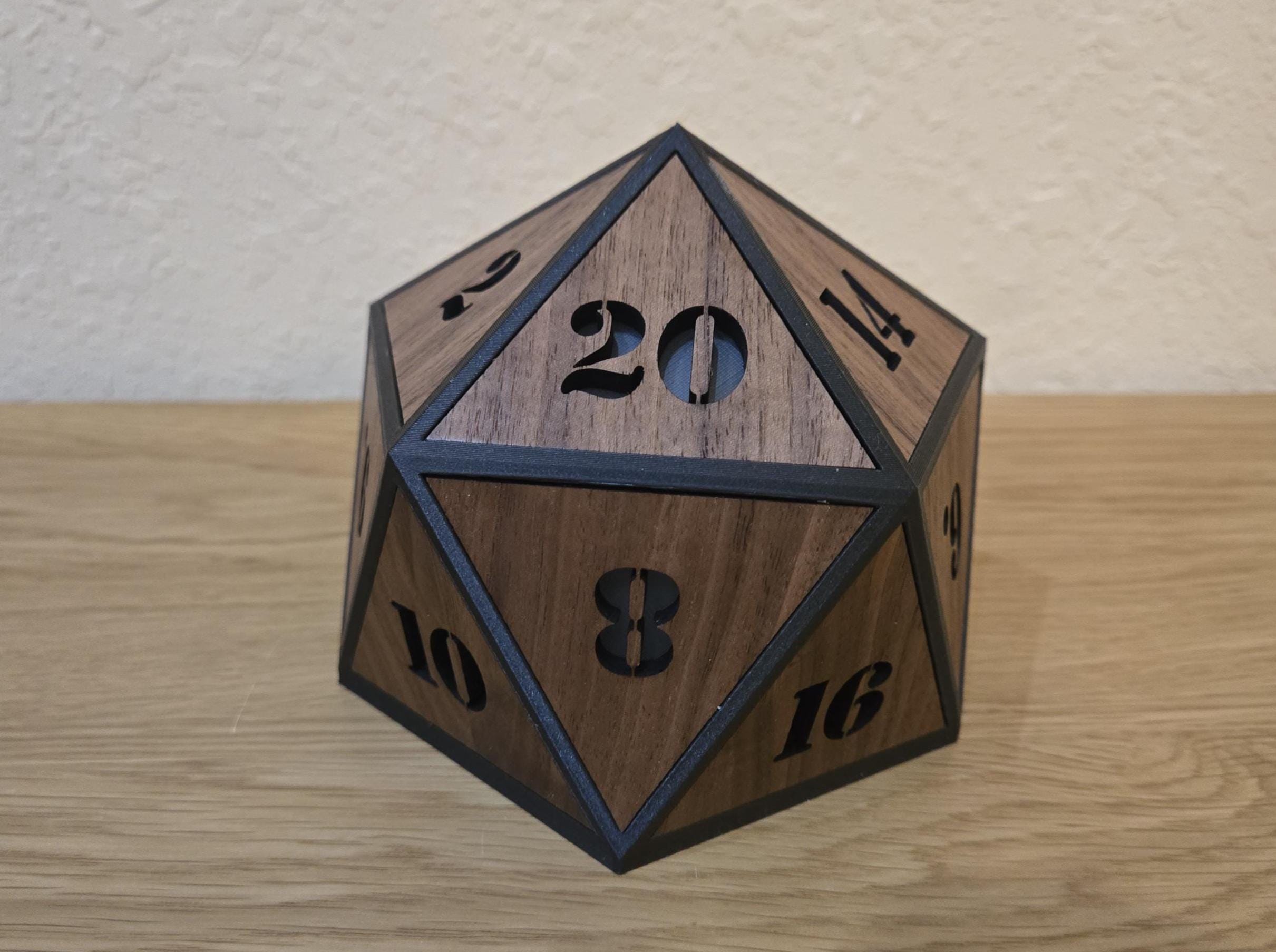 Unlit walnut D20 lamp showing the wood grain, number cutouts, and dark geometric edges from the front.