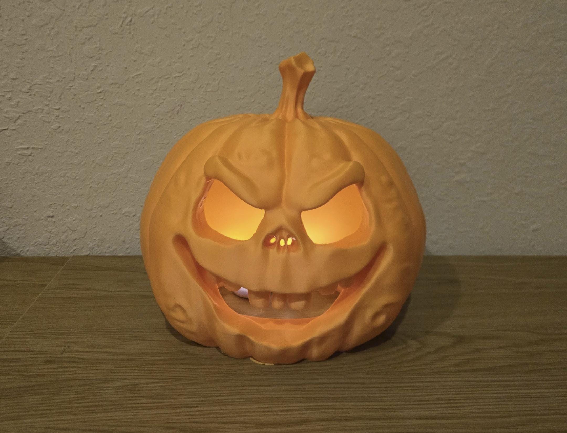 A glowing orange pumpkin with a carved face, placed on a wooden surface.