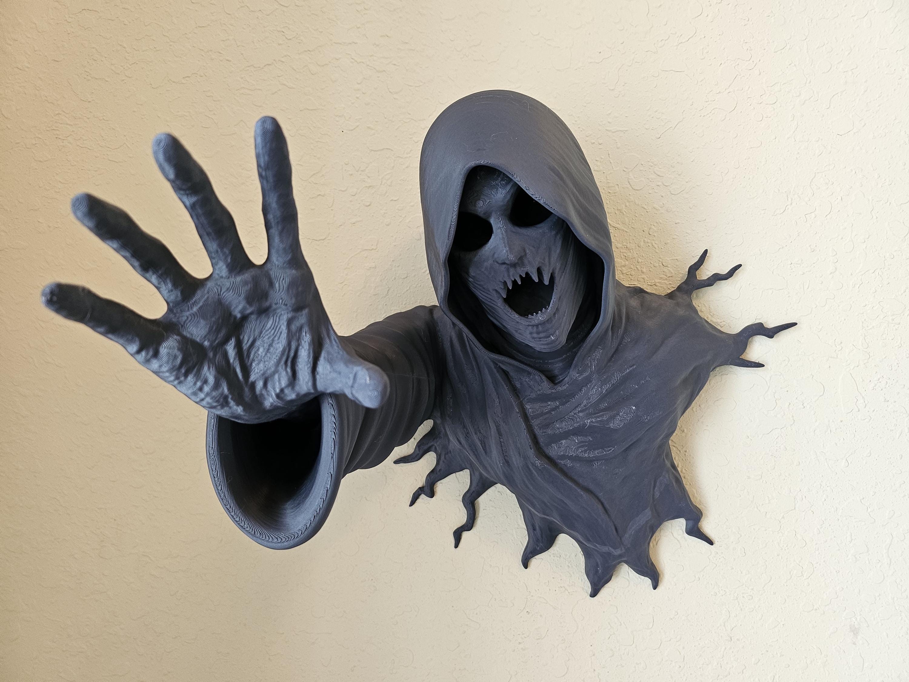 A black, 3D-printed void reaper wall decoration with a gothic ghost Halloween theme, featuring a hooded figure with outstret.