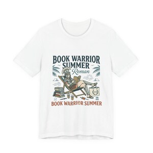 May include: A white t-shirt featuring a graphic illustration of a Roman soldier in armor and a helmet sitting in a beach chair reading a book. The text reads BOOK WARRIOR SUMMER Roman and BOOK WARRIOR SUMMER, with palm trees, books, and a tote bag.