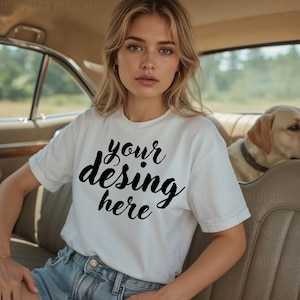 Può includere: Una maglietta bianca con la scritta "your desing here" in corsivo nero. La persona indossa la maglietta e pantaloncini di jeans blu. Un Labrador Retriever giallo è sullo sfondo.