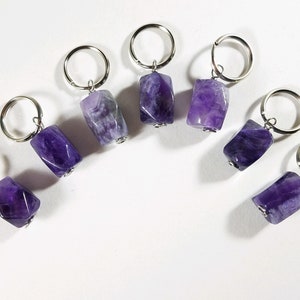 May include: Seven amethyst stone keychains with silver rings. Each keychain features a different shaped amethyst stone.