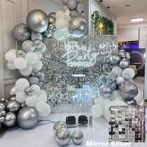 May include: A silver and white balloon arch with a silver sequin backdrop. The backdrop has a neon sign that says "Let's Get This Party Started".