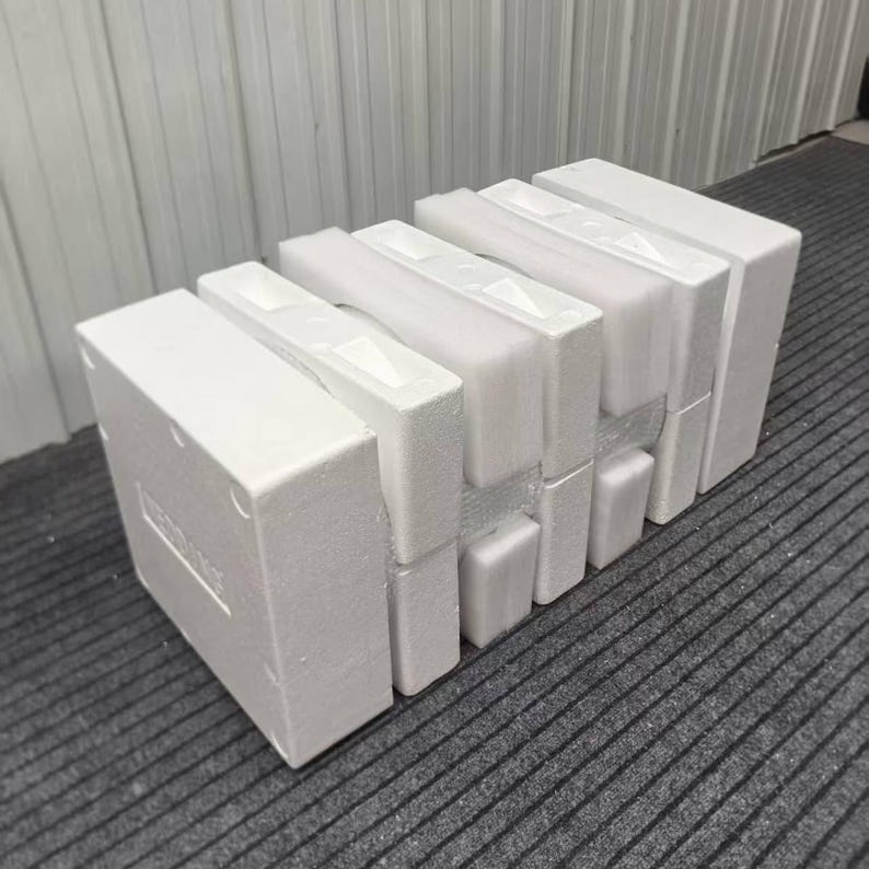 May include: White foam packaging inserts, designed to protect items during shipping. The inserts are made of lightweight foam and are arranged in a rectangular shape. The packaging is designed to fit together and provide cushioning.