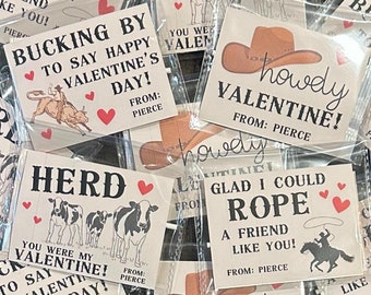 May include: A collection of Valentine's Day cards with a Western theme. The cards feature images of cows, horses, and cowboys, and include phrases like "Herd You Were My Valentine!" and "Bucking By To Say Happy Valentine's Day!"