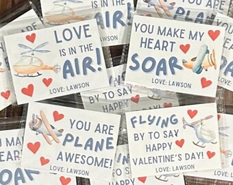 May include: A set of 10 Valentine's Day cards featuring airplanes and helicopters with cute sayings like "Love is in the air!" and "You are plane awesome!" Each card has a red heart and the text "Love: Lawson".