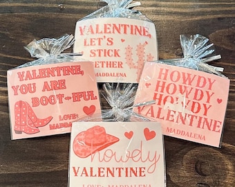 May include: Four pink and red Valentine's Day cards with different messages and designs. The cards feature a cowboy boot, a cactus, a cowboy hat, and the words "Howdy Howdy Howdy Valentine".