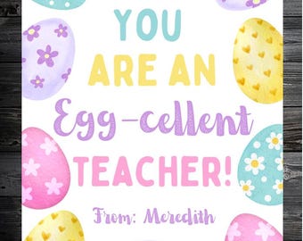 May include: A white card with colorful Easter eggs and the text "YOU ARE AN Egg-cellent TEACHER!" in pastel colors. The eggs are decorated with flowers and hearts. The card is signed "From: Meredith".