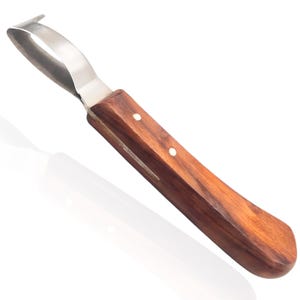 Può includere: Un coltello per zoccoli in acciaio inossidabile con manico in legno. Il manico è marrone con punti bianchi. Il coltello ha una lama curva.