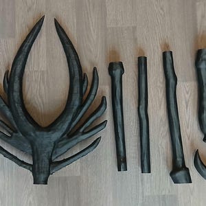 May include: A dark grey antler and several matching pieces, possibly for a costume or decorative project. The antler has a large, branching structure, and the other pieces are various lengths and shapes.