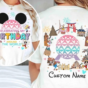 Op de afbeelding: Een wit t-shirt met een vooropdruk van Mickey Mouse-oren, een geodetische koepel en de tekst "CELEBRATING MY BIRTHDAY AROUND THE WORLD". De achterkant toont een geodetische koepel omringd door internationale bezienswaardigheden en figuren.