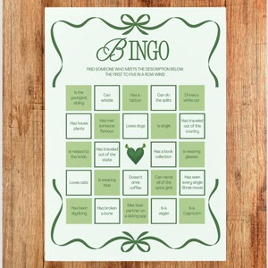 May include: A green and white Bingo game card with a decorative border. The card features a grid of descriptive prompts, such as "Loves dogs" and "Drives a white car." The word "BINGO" is at the top, and the instructions are below.