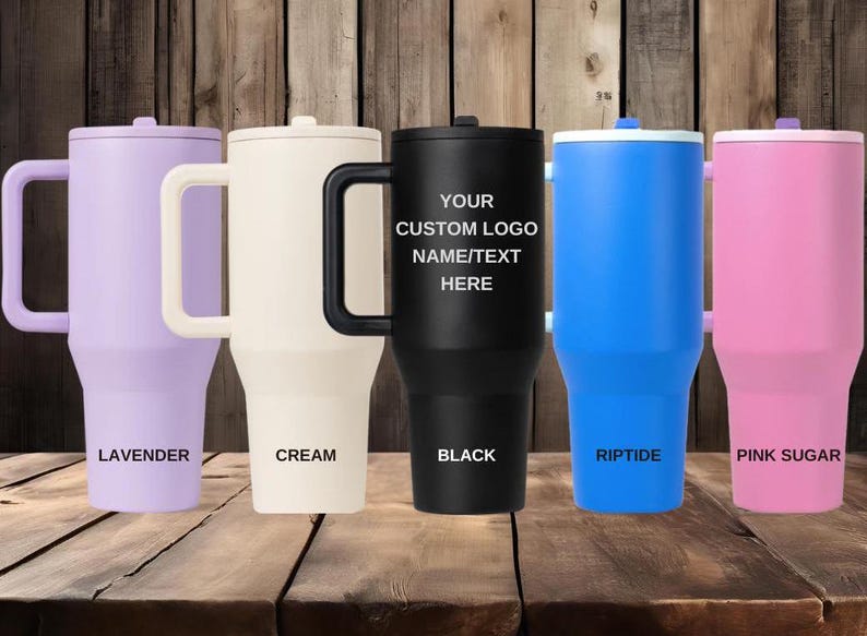 K&ouml;nnte beinhalten: F&uuml;nf hohe Isolierbecher mit Griffen, jeweils mit Deckel und konischem Boden. Die Farben von links nach rechts sind Lavendel, Creme, Schwarz, Blau und Pink. Der schwarze Becher zeigt den Text YOUR CUSTOM LOGO NAME/TEXT HERE.