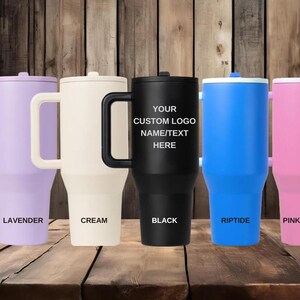 Puede incluir: Cinco vasos aislados en lavanda, crema, negro, azul y rosa. Cada vaso tiene un asa y una tapa. El vaso negro tiene el texto "YOUR CUSTOM LOGO NAME/TEXT HERE". Los otros vasos tienen los textos "LAVENDER", "CREAM", "RIPTIDE" y "PINK SUGAR".
