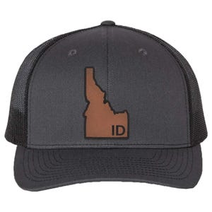 May include: A black and brown trucker hat with a brown leather patch featuring the outline of the state of Idaho and the letters "ID".