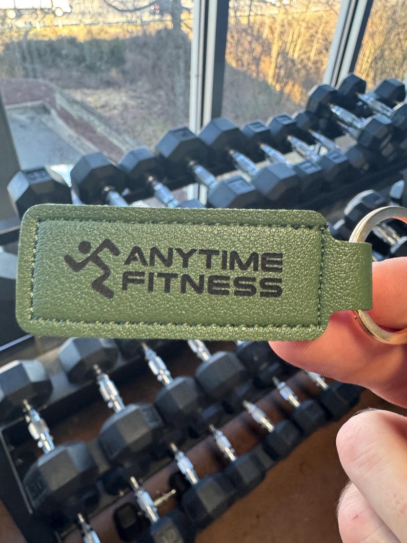 May include: Green leather keychain with a silver key ring and the text "ANYTIME FITNESS" and a running person logo.