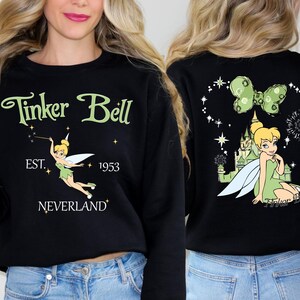 a woman wearing a black tinker bell sweatshirt