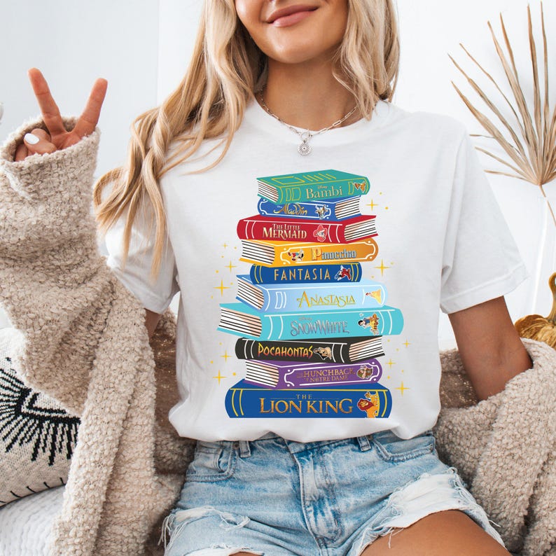 a woman wearing a white shirt with a stack of books on it