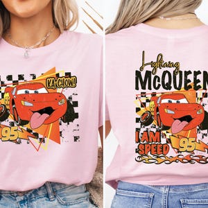 a woman wearing a pink disney cars t - shirt