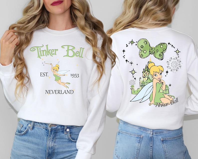 a woman wearing a tinker bell sweatshirt and jeans