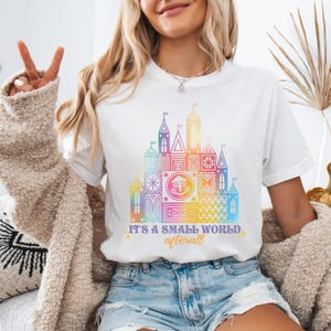 a woman wearing a t - shirt that says it's a magic world