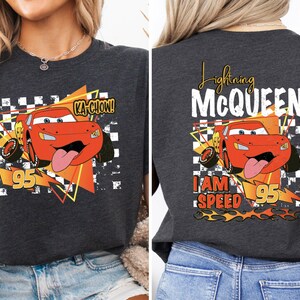 a woman wearing a black t - shirt with a cartoon character on it