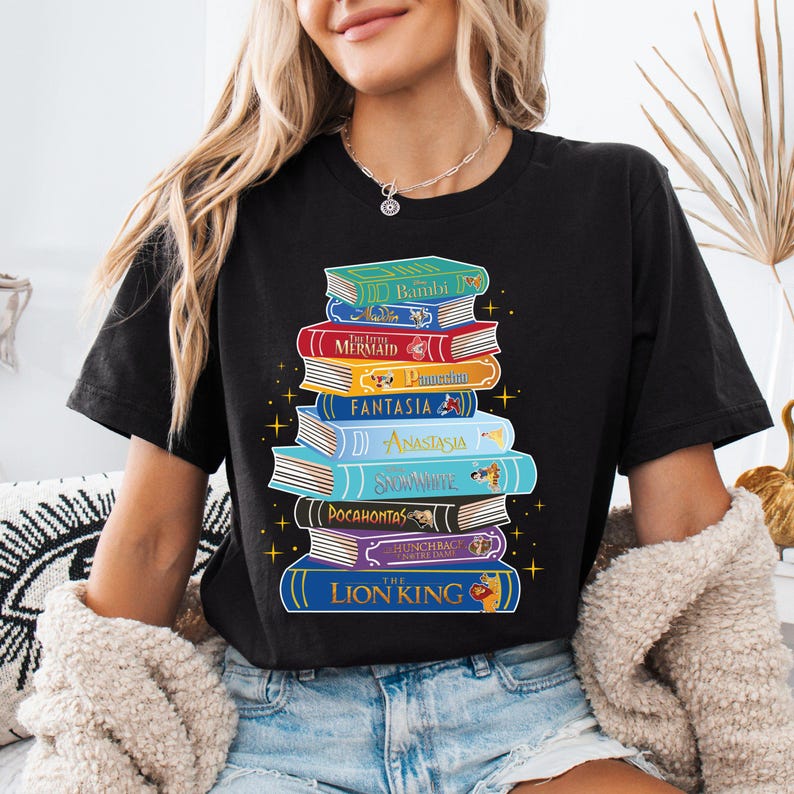 a woman wearing a black shirt with a stack of books on it