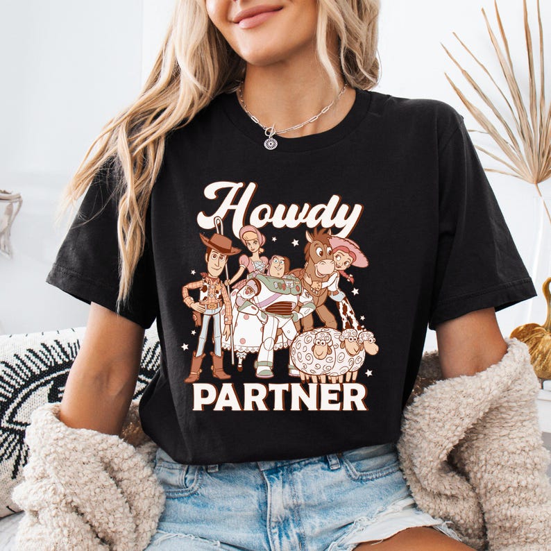 a woman wearing a black t - shirt with cartoon characters on it