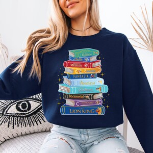 a woman sitting on a bed with a stack of books on her shirt