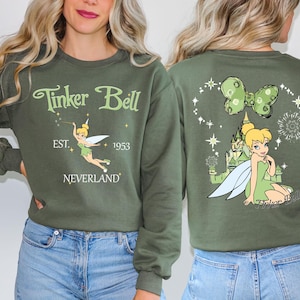 a woman wearing a green tinker bell sweatshirt