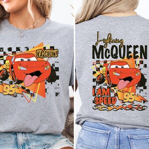 a woman wearing a gray t - shirt with a cartoon character on it