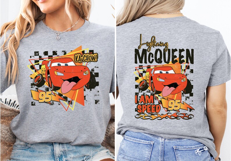 a woman wearing a gray t - shirt with a cartoon character on it