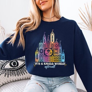 a woman wearing a sweatshirt that says it's a small world