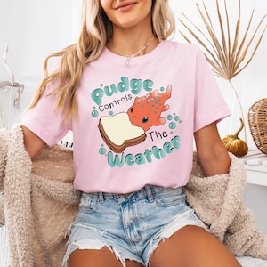 a woman wearing a pink t - shirt with a picture of a dog on it