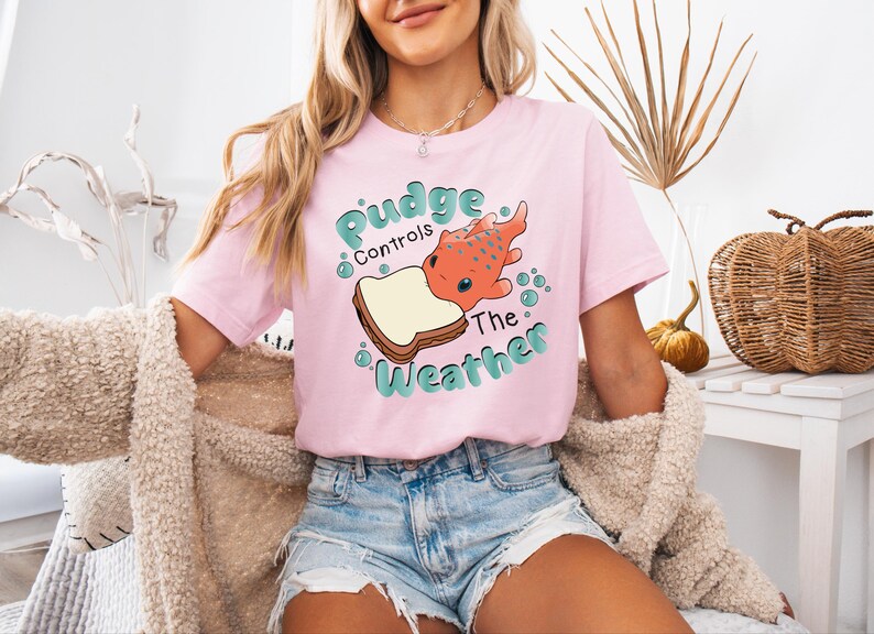 a woman wearing a pink t - shirt with a picture of a dog on it
