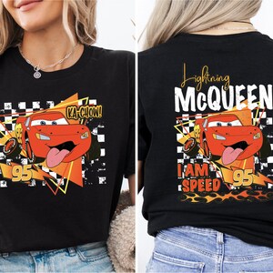 a woman wearing a black t - shirt with a cartoon character on it