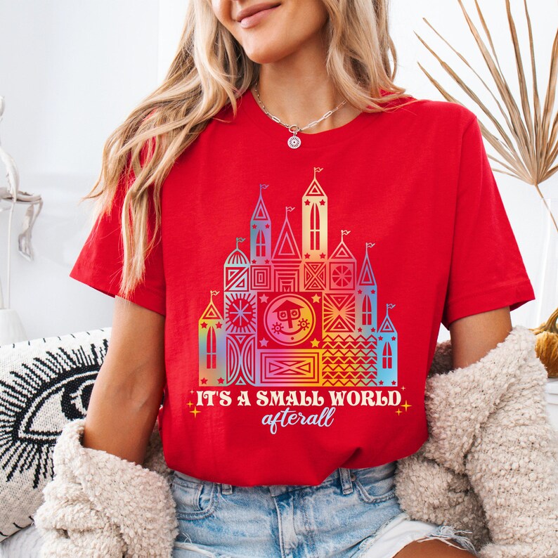 a woman wearing a red tshirt that says it's a small world