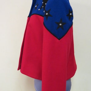 May include: A red and blue jacket with black star embellishments. The jacket has a cropped style and long sleeves.