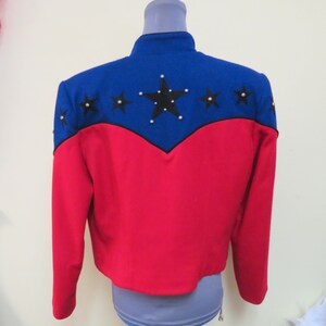 May include: A red and blue jacket with a star design on the back. The stars are black with silver accents.
