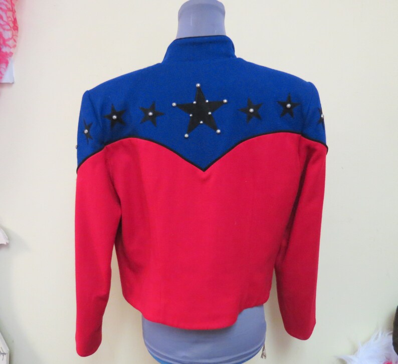 May include: A red and blue jacket with a star design on the back. The stars are black with silver accents.