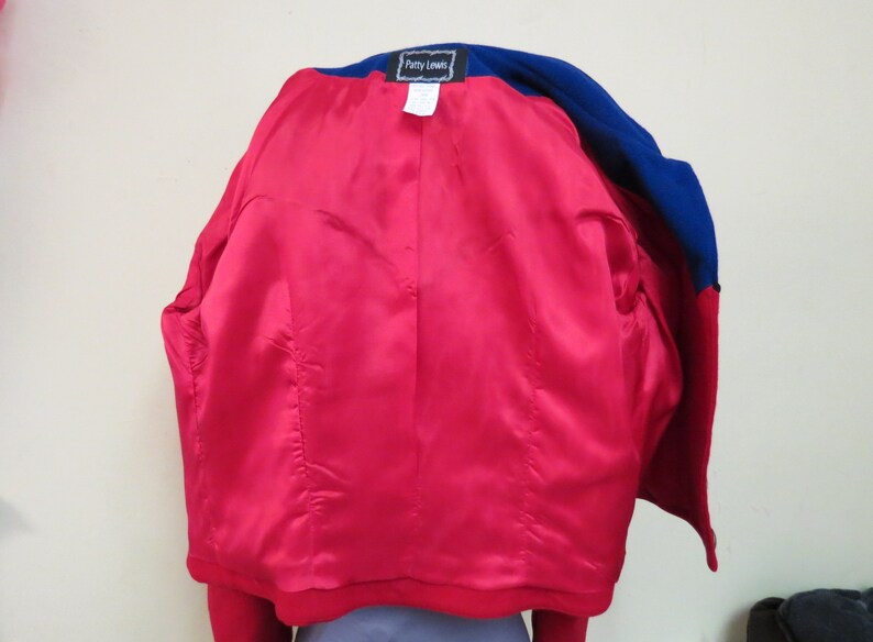 May include: A red and blue blazer with a satin lining. The blazer has a label that reads "Patty Leans".