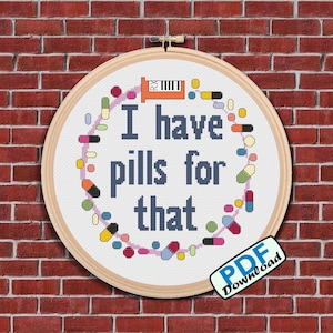 Könnte beinhalten: Ein weißer Stickrahmen mit einem Kreuzstich-Design aus bunten Pillen und dem Text "Ich habe Pillen dafür".