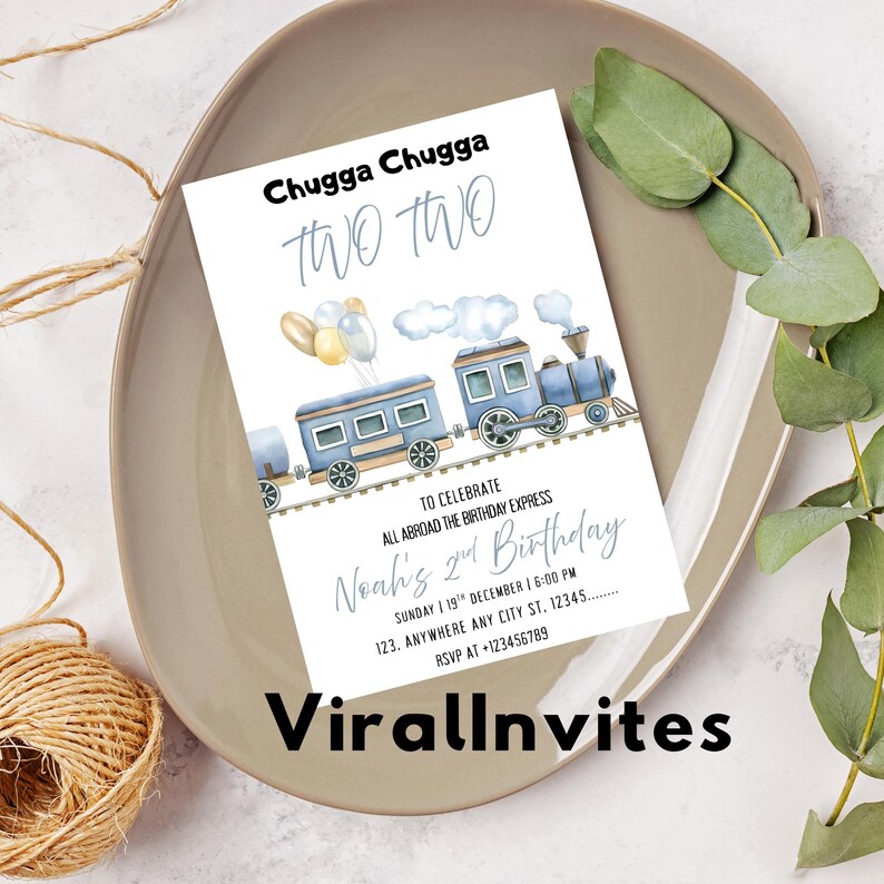 May include: A birthday invitation with a train theme. The invitation features a blue train illustration with the text "Chugga Chugga TWO TWO" at the top. The invitation is for Noah's 2nd birthday.